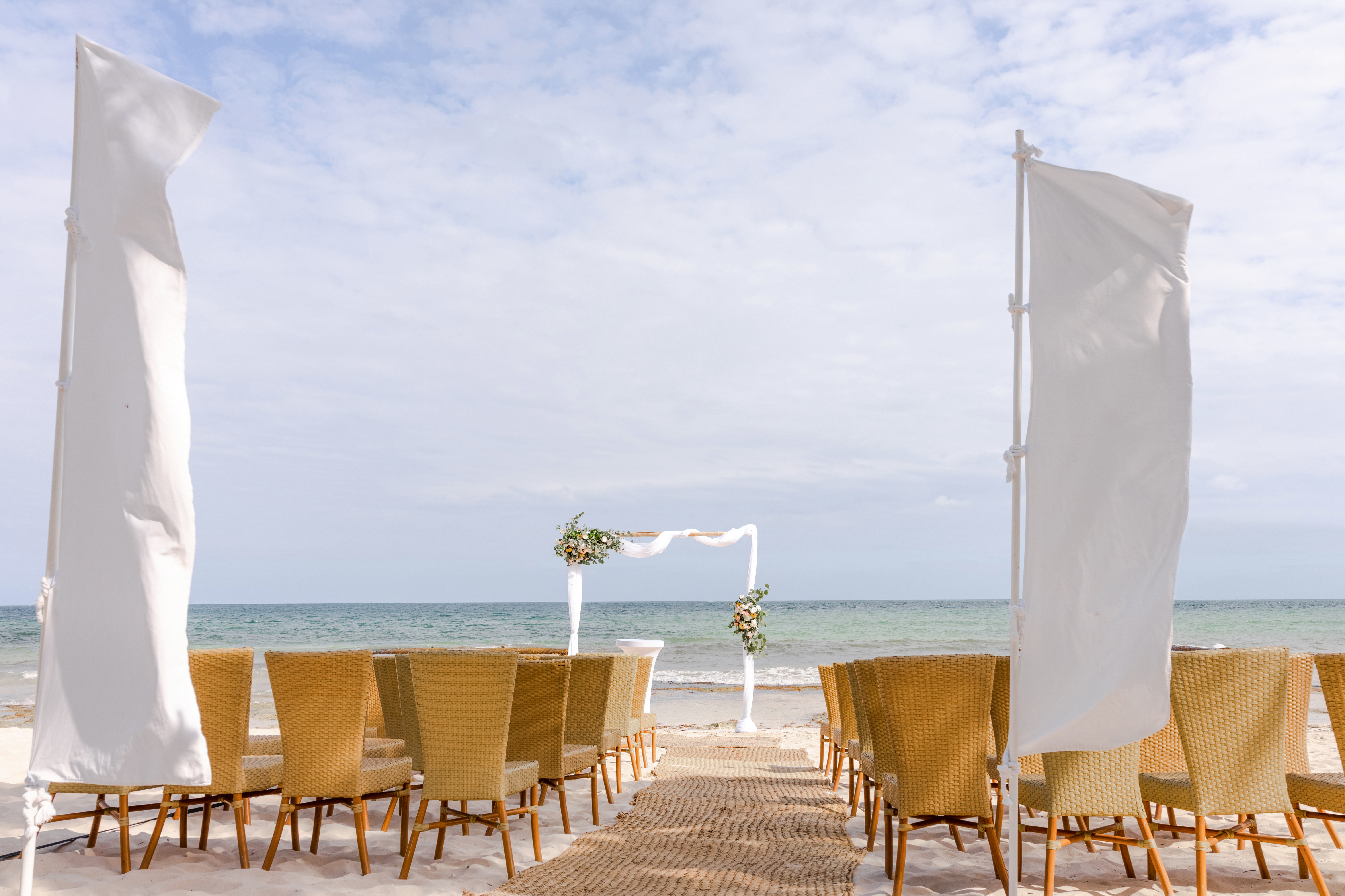 Luxury destination wedding ceremony on a white-sand beach in Cancún Mexico at golden hour
